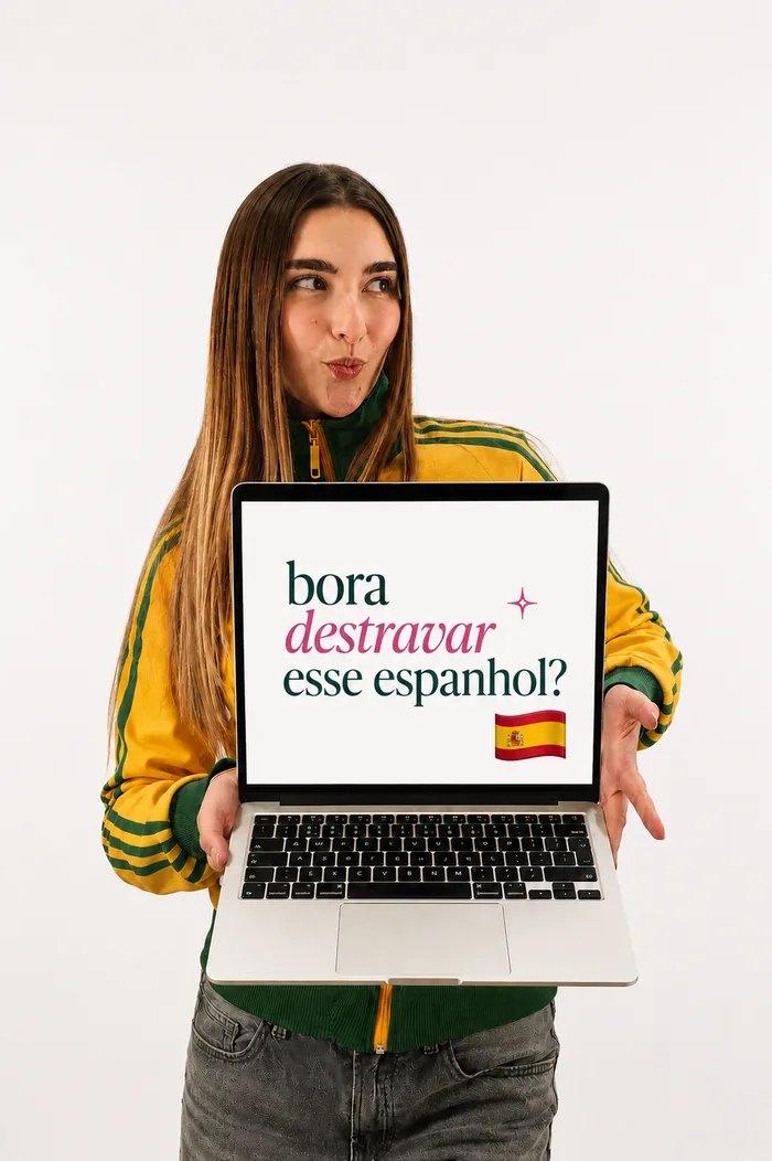 Amanda segurando um notebook com a pergunta "bora destravar esse espanhol?" na tela