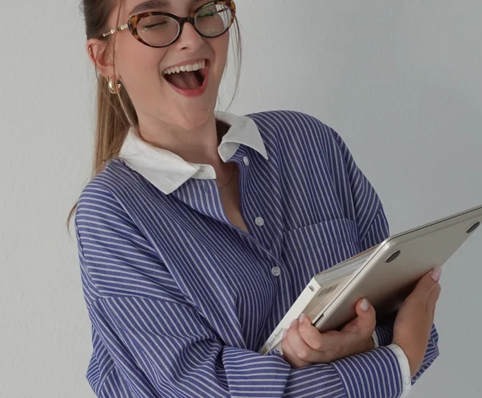Amanda rindo, segurando um notebook